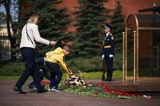 Laying flowers to the Eternal Flame. Eternal Flame in the Kremlin. Guard of Honor at the tomb of the Unknown Soldier at the wall of Moscow Kremlin. 11.05.2022 Moscow, Russia.