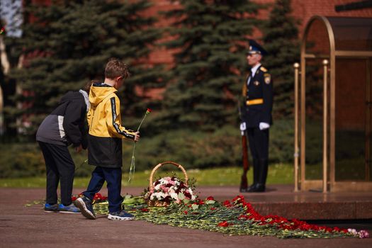 Laying flowers to the Eternal Flame. Eternal Flame in the Kremlin. Guard of Honor at the tomb of the Unknown Soldier at the wall of Moscow Kremlin. 11.05.2022 Moscow, Russia.