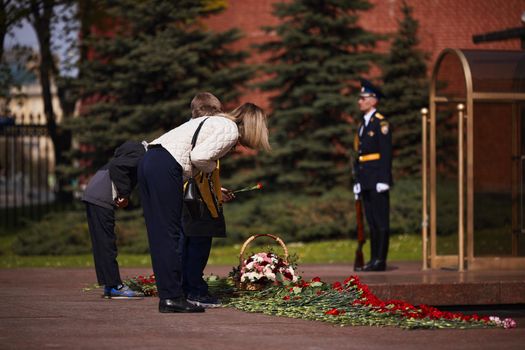 Laying flowers to the Eternal Flame. Eternal Flame in the Kremlin. Guard of Honor at the tomb of the Unknown Soldier at the wall of Moscow Kremlin. 11.05.2022 Moscow, Russia.