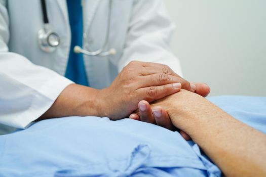 Doctor holding hands Asian elderly woman patient, help and care in hospital.