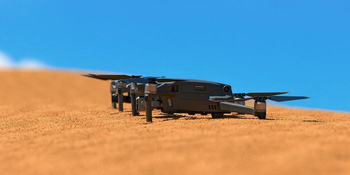 Quadrocopters are built on the sand in the desert waiting for takeoff.