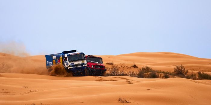 The rivalry between Kamaz and Maz at the rally. Sports truck KAMAZ gets over the difficult part of the route during the Rally raid in sand. THE GOLD OF KAGAN-2021. 26.04.2021 Astrakhan, Russia.