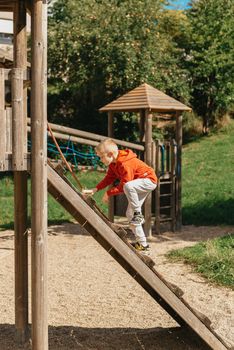 Funny cute happy baby playing on the playground. The emotion of happiness, fun, joy. Smile of a child. boy playing on the playground.