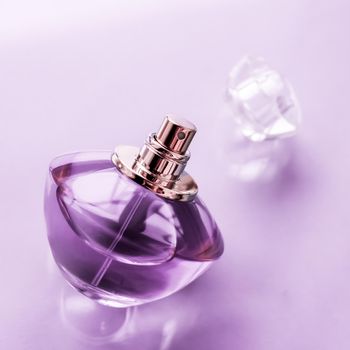 Perfumery, spa and branding concept - Purple perfume bottle on glossy background, sweet floral scent, glamour fragrance and eau de parfum as holiday gift and luxury beauty cosmetics brand design