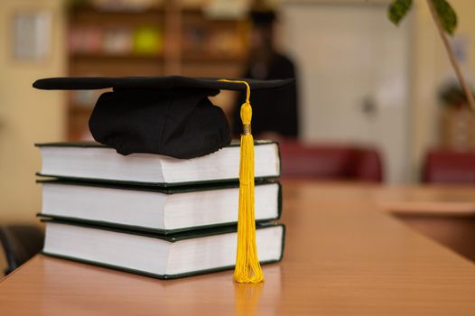 Graduation cap on a stack of books in the library