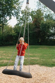 Funny cute happy baby playing on the playground. The emotion of happiness, fun, joy. Smile of a child. boy playing on the playground.