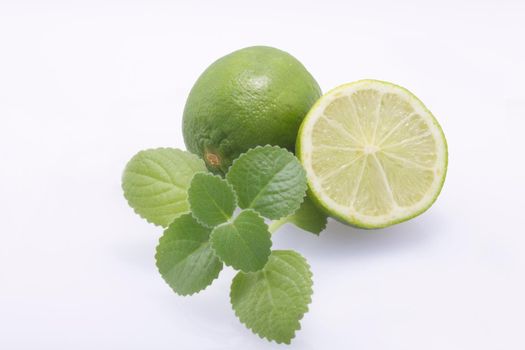 Fresh, natural, green limes, cut in half and whole, fresh mint on a white background.