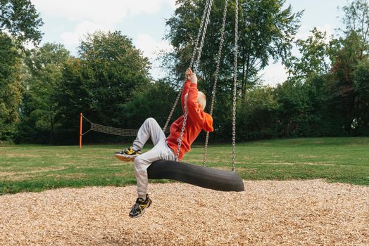 Funny cute happy baby playing on the playground. The emotion of happiness, fun, joy. Smile of a child. boy playing on the playground.