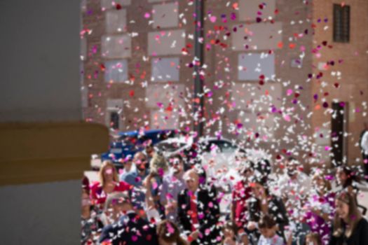 Blurred on purpose. Family throwing rose petals at the newly wed bride and groom. Just married.