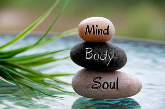 Mind, Body and Soul words engraved on zen stones with space for text. Copy space and zen concept.