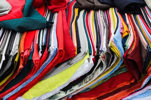 Detailed close up view on samples of cloth and fabrics in different colors found at a fabrics market.