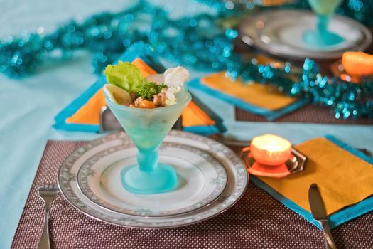 Festively served table, anticipation of Christmas, sea salad in turquoise bowls. High quality photo