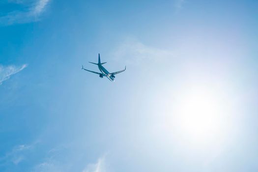 the plane is flying against the blue sky. photo