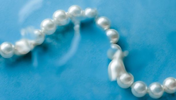 Jewelry, branding and gems concept - Coastal jewellery fashion, pearl necklace under blue water background, glamour style present and chic gift for luxury jewelery brand, holiday banner design