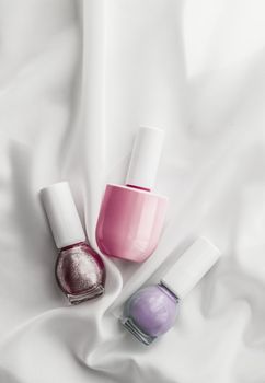 Cosmetic branding, salon and glamour concept - Nail polish bottles on silk background, french manicure products and nailpolish make-up cosmetics for luxury beauty brand and holiday flatlay art design