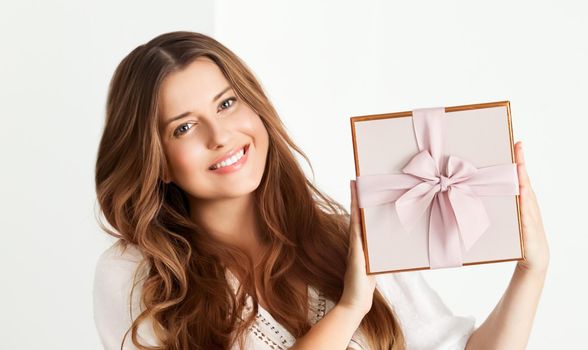 Holiday present for birthday, baby shower, wedding or luxury beauty box subscription delivery, happy woman holding a wrapped pink gift on white background