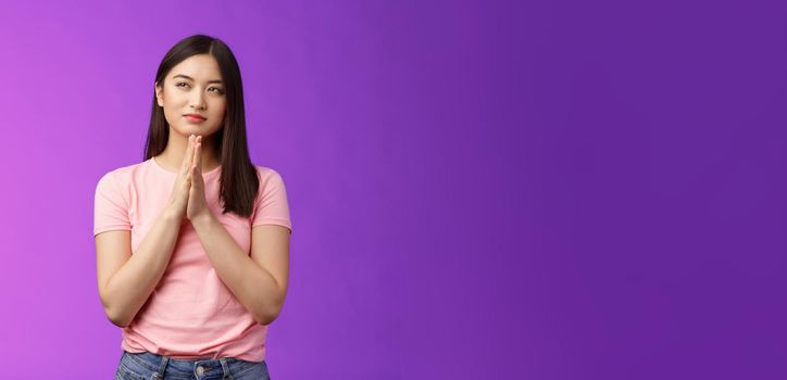 Cunning smart good-looking asian woman rubbing hands together scheming, squinting suspicious focused have evil plan, look upper left corner, sly idea, stand purple background. Copy space