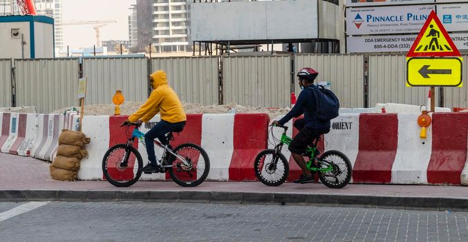 Dubai, UAE - 09.29.2022 - Teenagers riding their bikes at Business Bay district