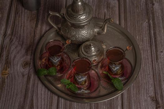 tray with glasses and serving pitcher of authentic Moorish tea ready to drink with mint leaves