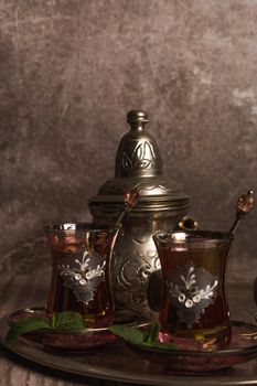 tray with glasses and serving pitcher of authentic Moorish tea ready to drink with mint leaves