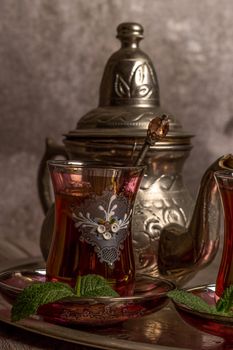 tray with glasses and serving pitcher of authentic Moorish tea ready to drink with mint leaves