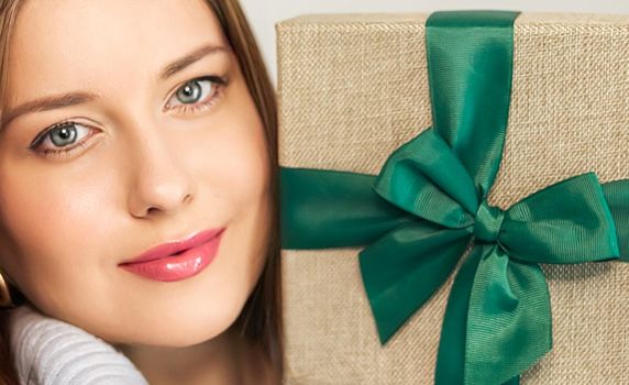 Winter holidays, present and Merry Christmas concept, happy woman smiling and holding wrapped gift box, close-up portrait