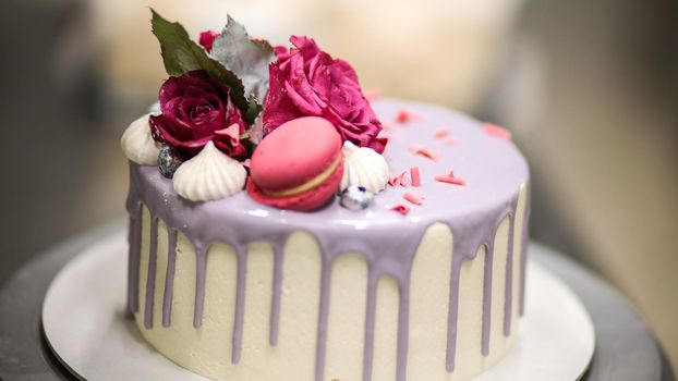 chef usign macaron , flowers and text sign for a celebration cake