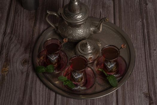 tray with glasses and serving pitcher of authentic Moorish tea ready to drink with mint leaves