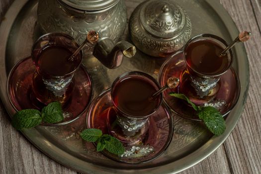 tray with glasses and serving pitcher of authentic Moorish tea ready to drink with mint leaves