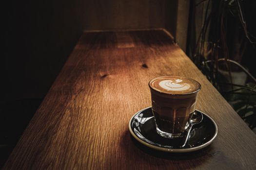 A cup of coffee latte top view with leaf shape foam