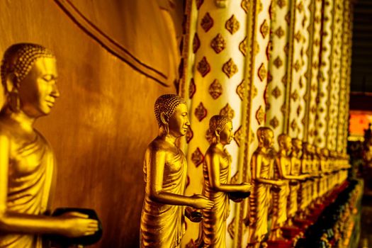 Row of Golden buddha statue in asian temple with beautiful decoration.
