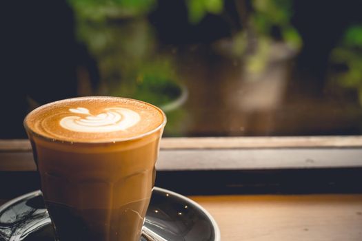 A cup of coffee latte top view with leaf shape foam