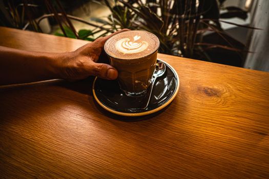 A cup of coffee latte top view with leaf shape foam