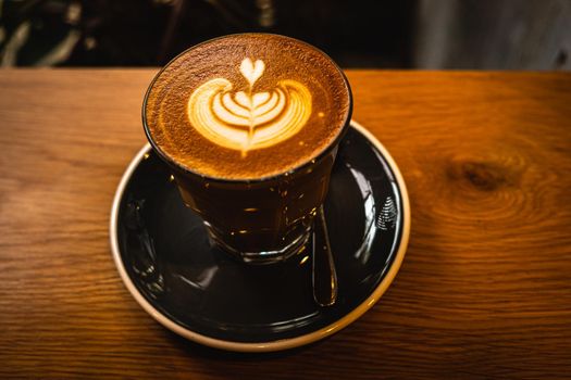 A cup of coffee latte top view with leaf shape foam