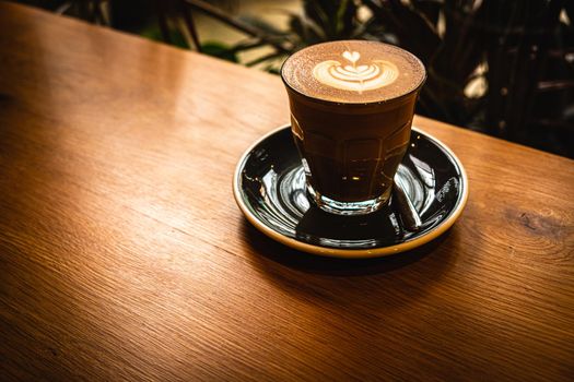 A cup of coffee latte top view with leaf shape foam