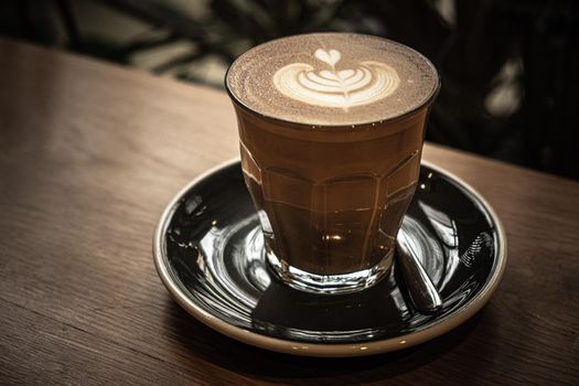 A cup of coffee latte top view with leaf shape foam