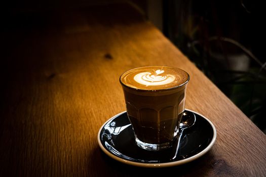 A cup of coffee latte top view with leaf shape foam