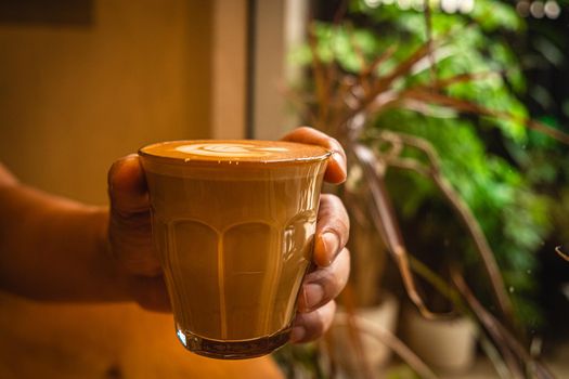 A cup of coffee latte top view with leaf shape foam