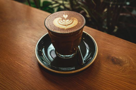 A cup of coffee latte top view with leaf shape foam