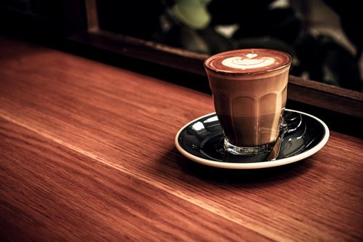 A cup of coffee latte top view with leaf shape foam