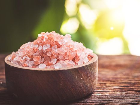 Himalayan salt raw crystals in wood bowl nature background