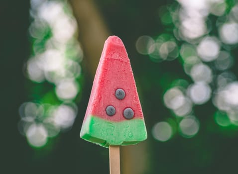 H ice cream or popsicles in shape of waterlamon on nature background, frozen fruit juice.