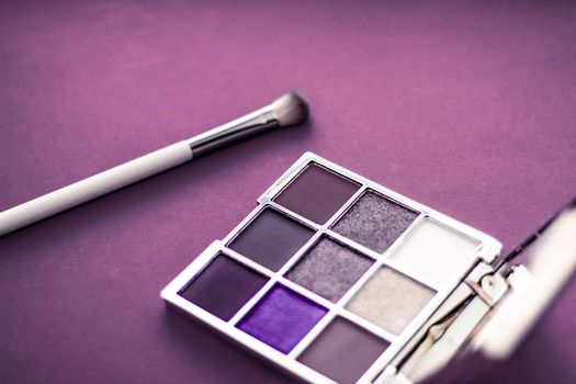 Cosmetic branding, mua and girly concept - Eyeshadow palette and make-up brush on purple background, eye shadows cosmetics product as luxury beauty brand promotion and holiday fashion blog design