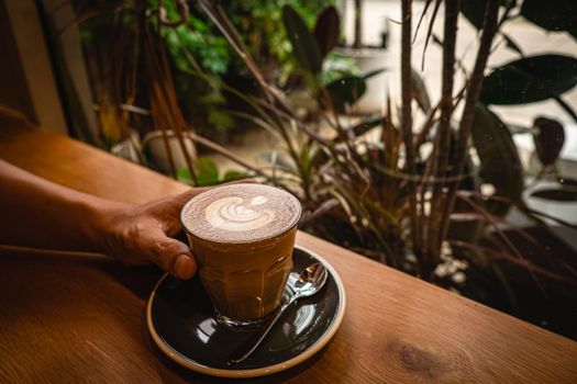 A cup of coffee latte top view with leaf shape foam