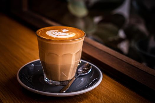 A cup of coffee latte top view with leaf shape foam