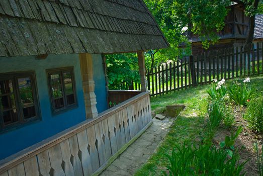 A typical Ukrainian landscape in spring or summer: white clay hut with a straw roof and a tree in the foreground.