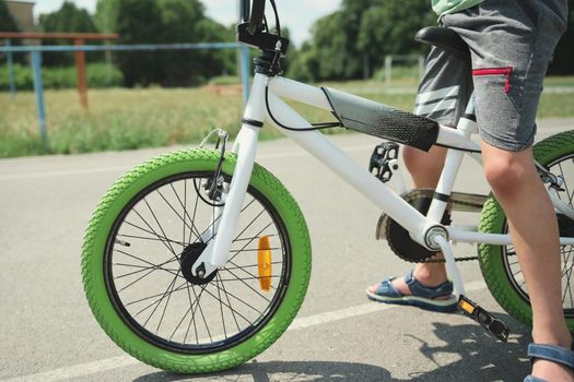 Details: bicycle chain wheel frame, parts bicycle wheel, cycling road bike frame. Cropped view of child boy riding bike. Active lifestyle and sports concept