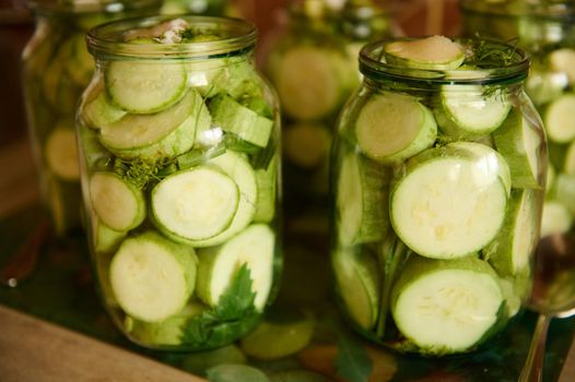 Pickling. Canning. Marinating. Preserving homegrown vegetables for the winter. Organic sliced zucchini, courgettes, or vegetable marrows, marinated in brine, salt, or vinegar. Home canned food