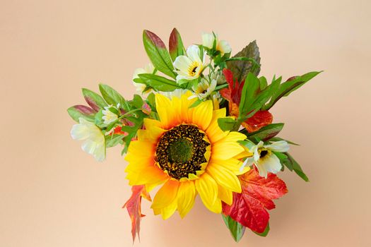 fall bouquet on a light background with a place for text. sunflower and autumn leaves. copy space