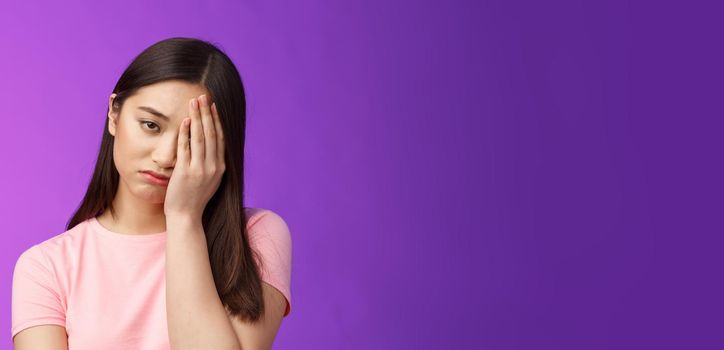 Close-up tired upset girl feeling loser, punch face, make facepalm sign sighing sorrow, exhausted doing hard homework, stand unhappy purple background, regret missed chance. Copy space